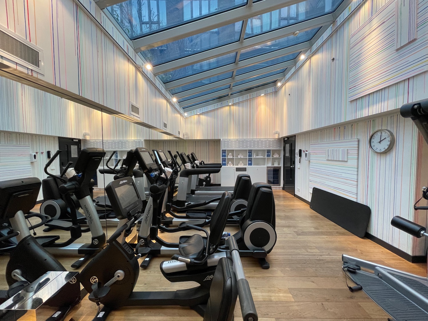 a room with exercise machines and a glass roof