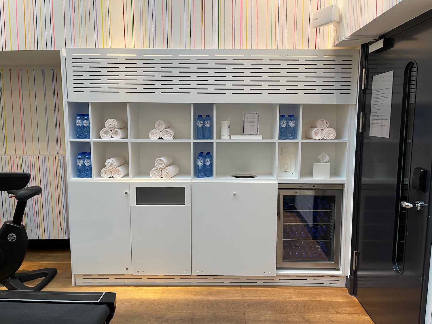 a white shelves with towels and bottles on it