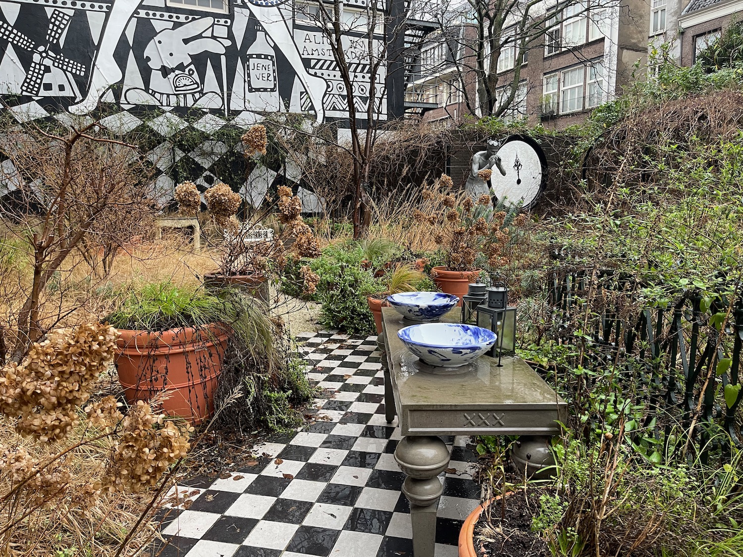 a table with bowls on it and plants in pots