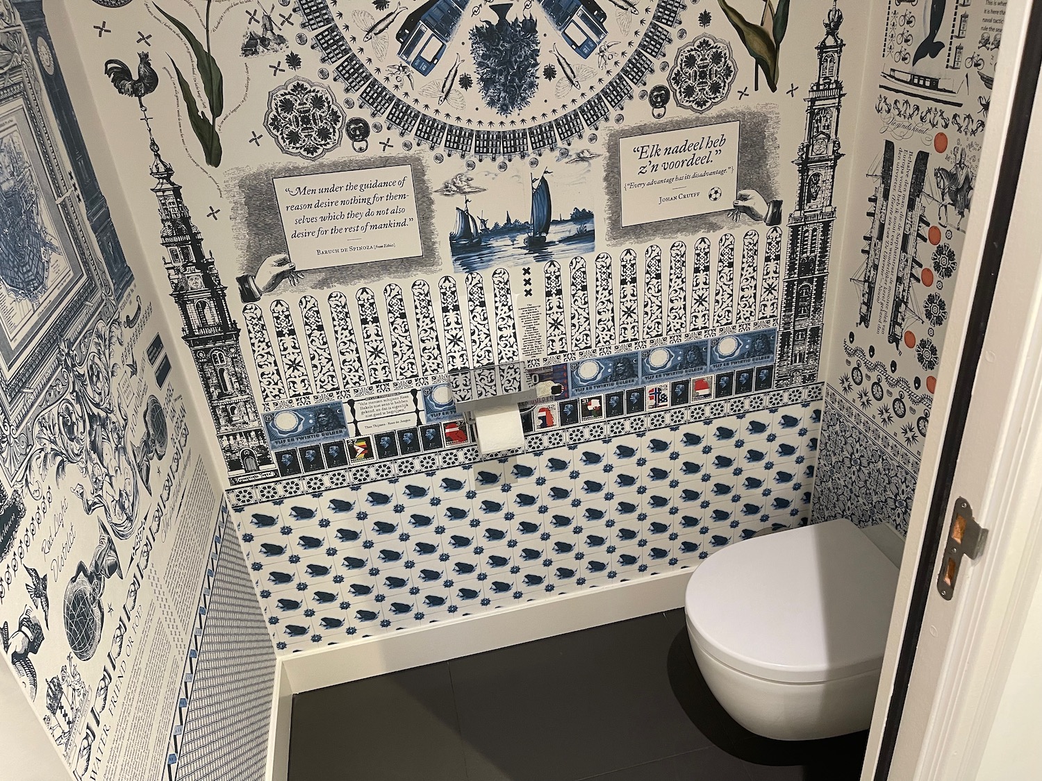 a bathroom with a toilet and a wallpaper