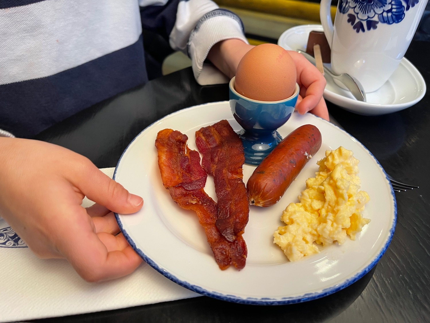 a plate of food with a egg and bacon