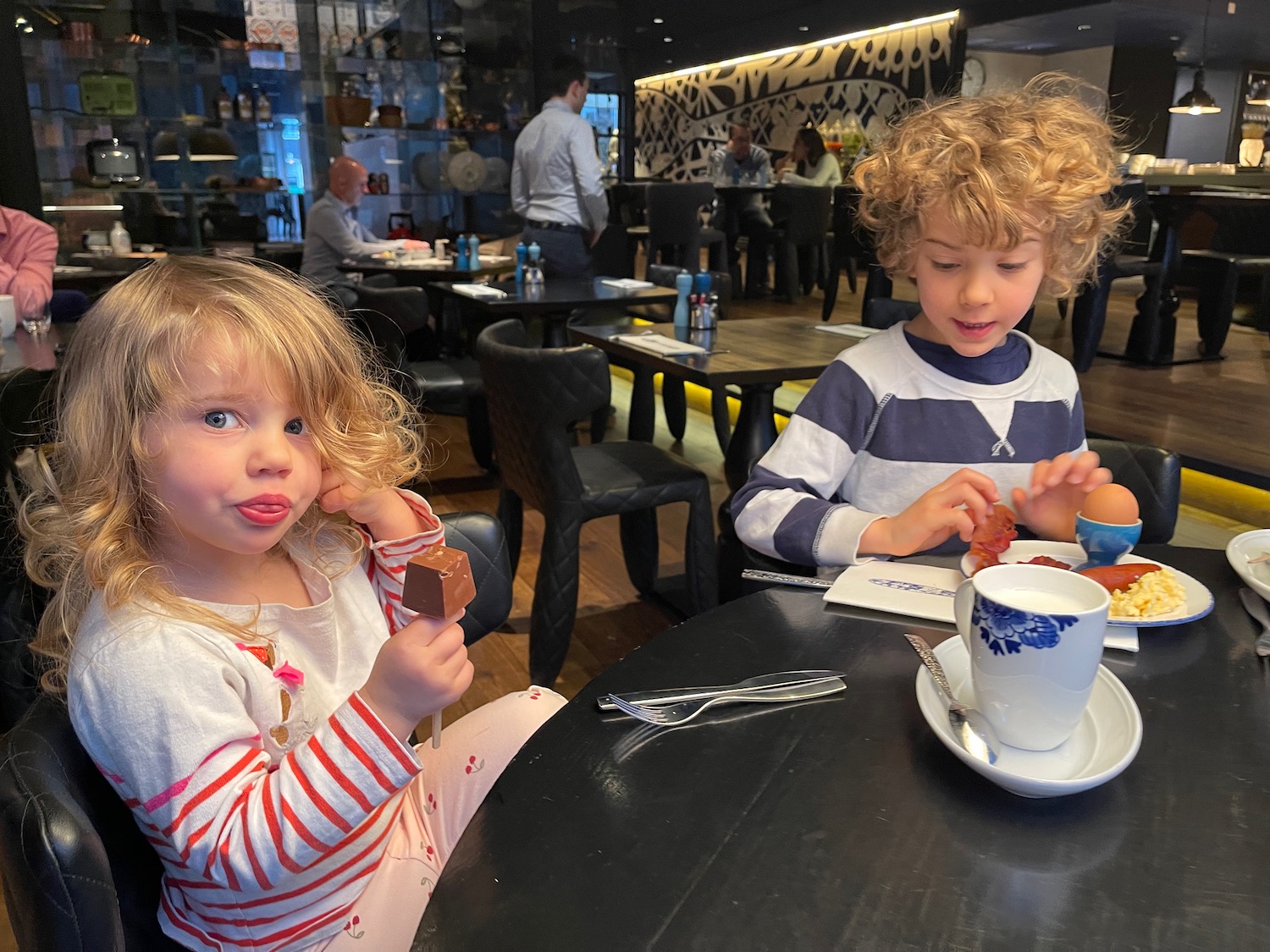 a boy and girl sitting at a table eating food