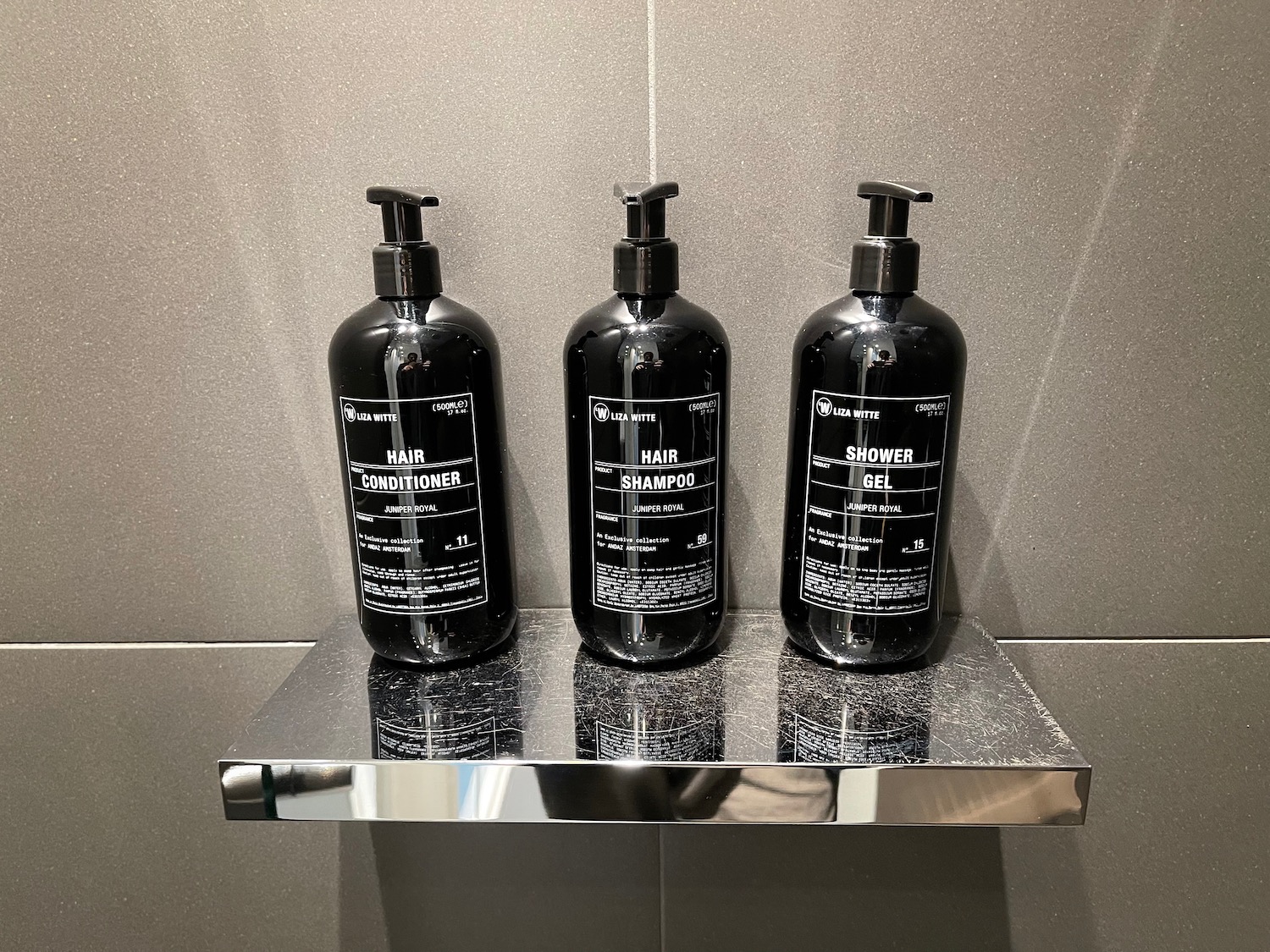 a group of black bottles on a silver shelf