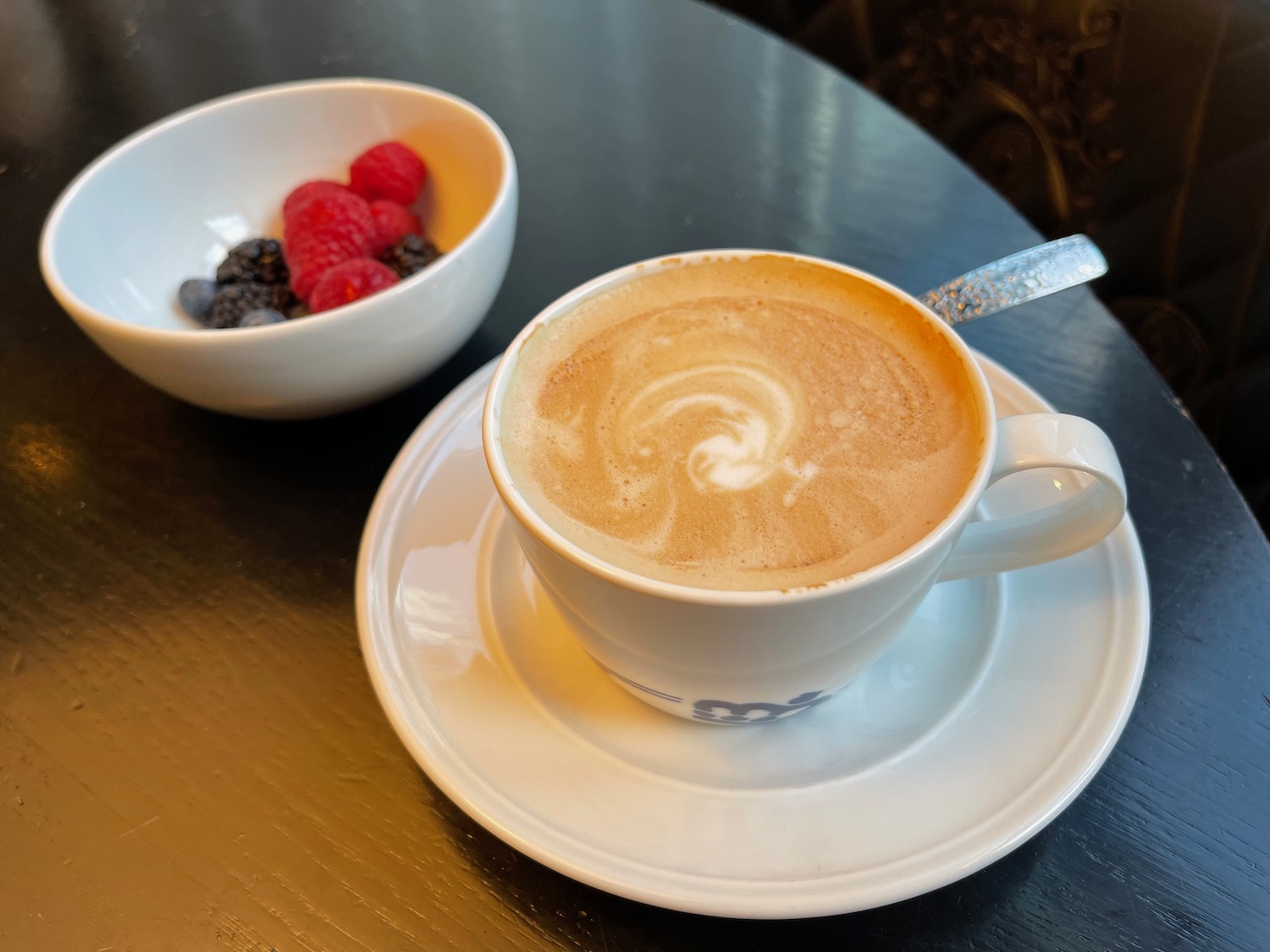 a cup of coffee and a bowl of berries