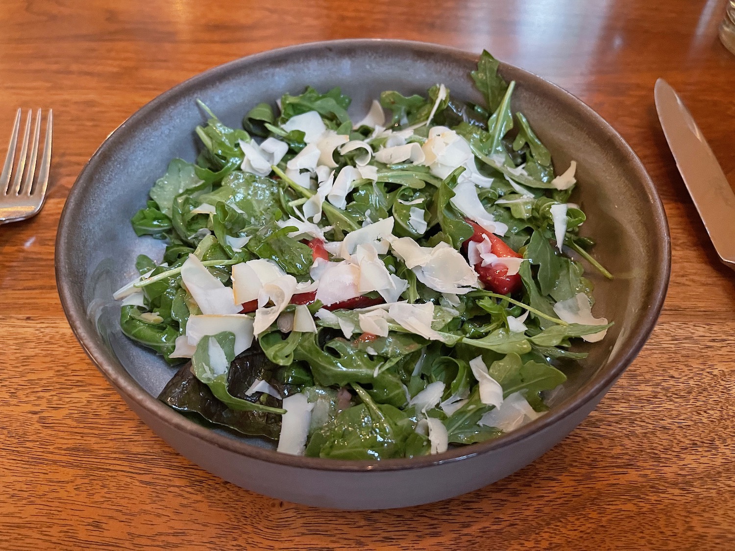 a bowl of salad with cheese and greens
