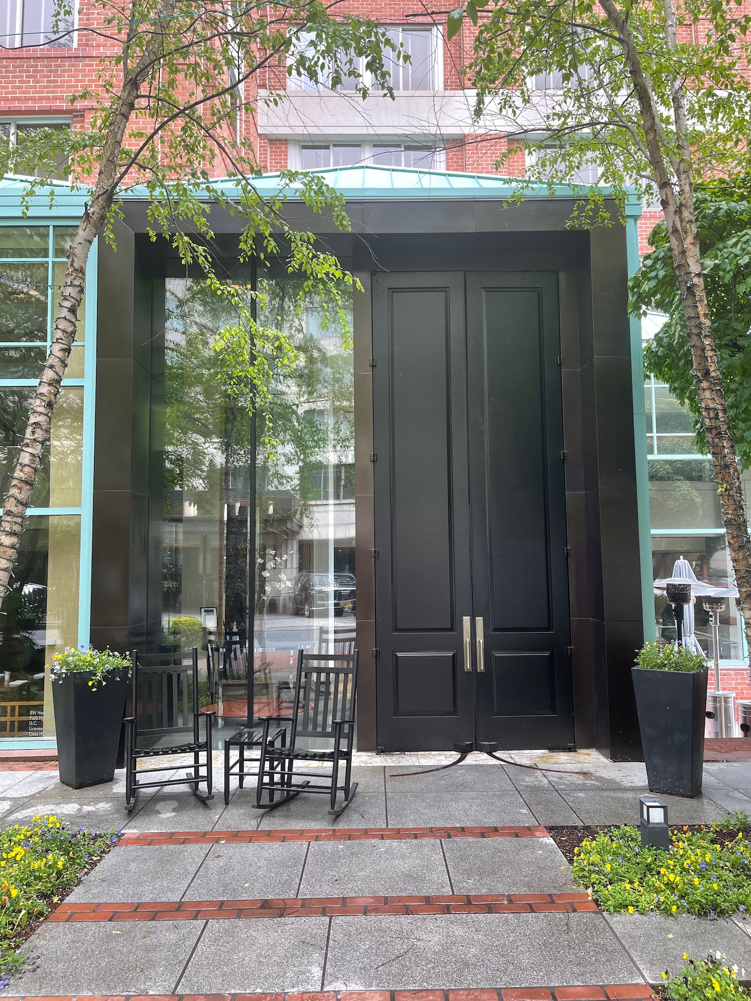 a black doors with chairs in front of a building