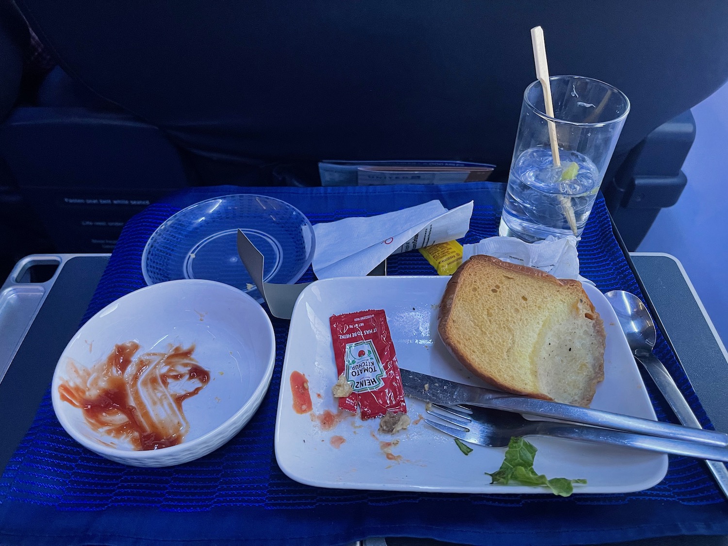 a plate of food and a glass of water on a blue table
