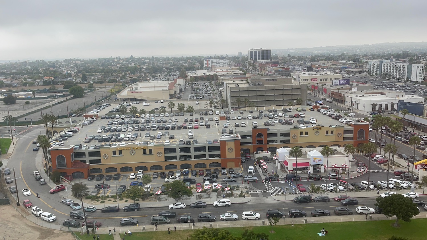 a parking lot with cars and buildings in the background