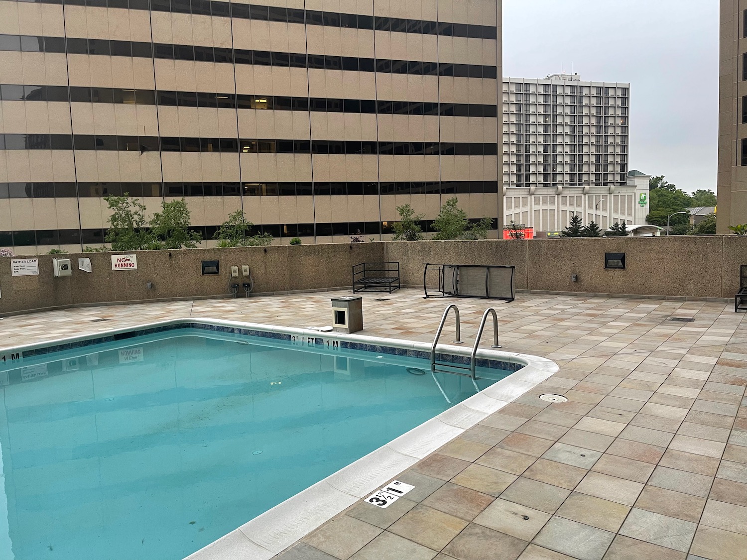 a pool with stairs and a building in the background