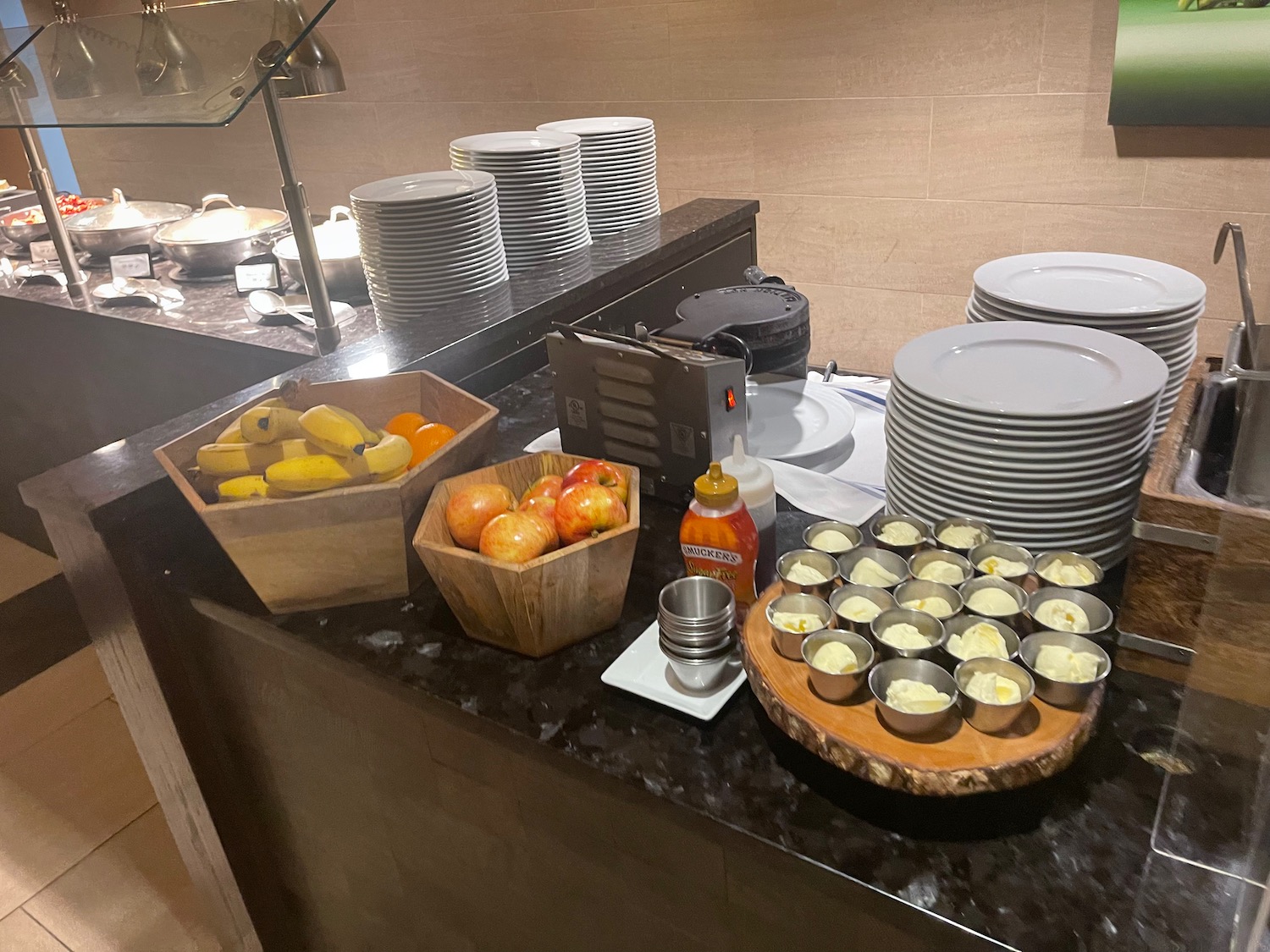 a buffet table with plates and bowls of fruit