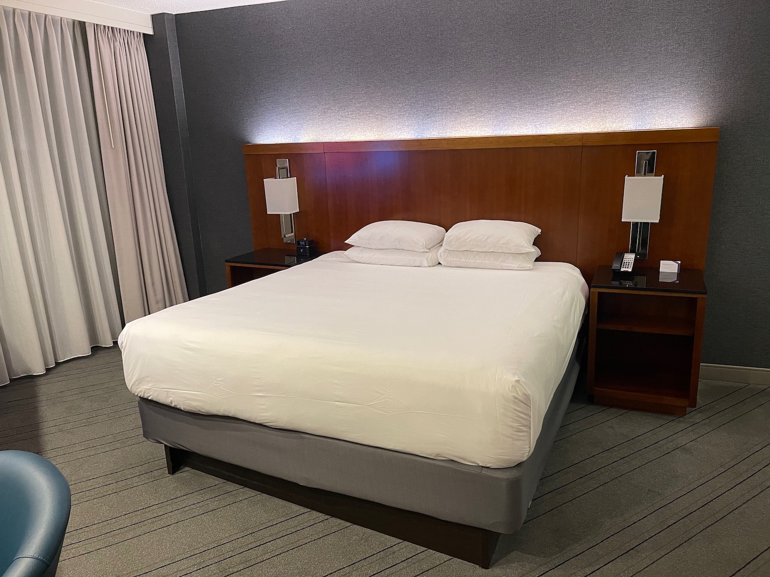 a bed with white sheets and a wood headboard