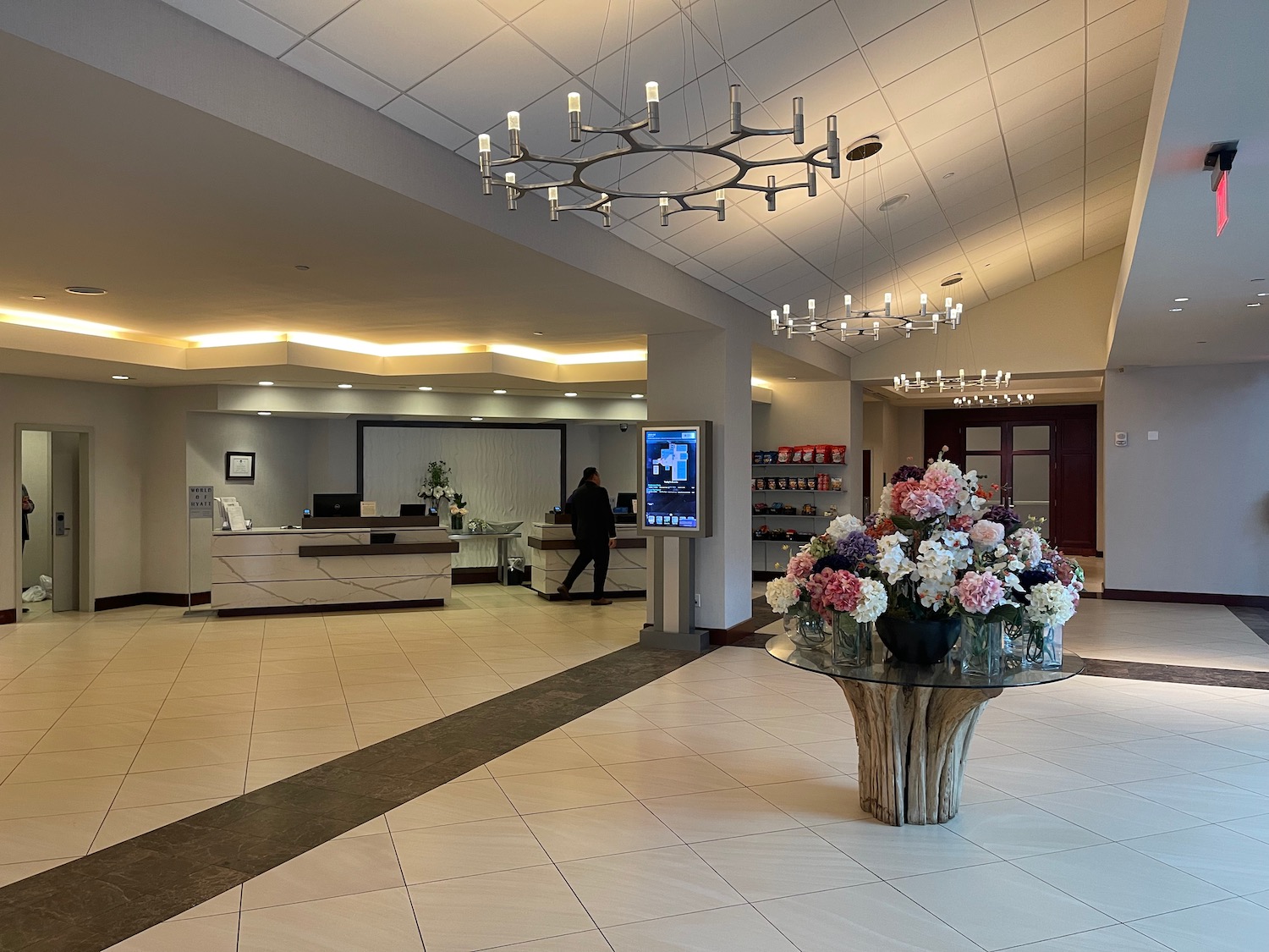 a large lobby with a table of flowers