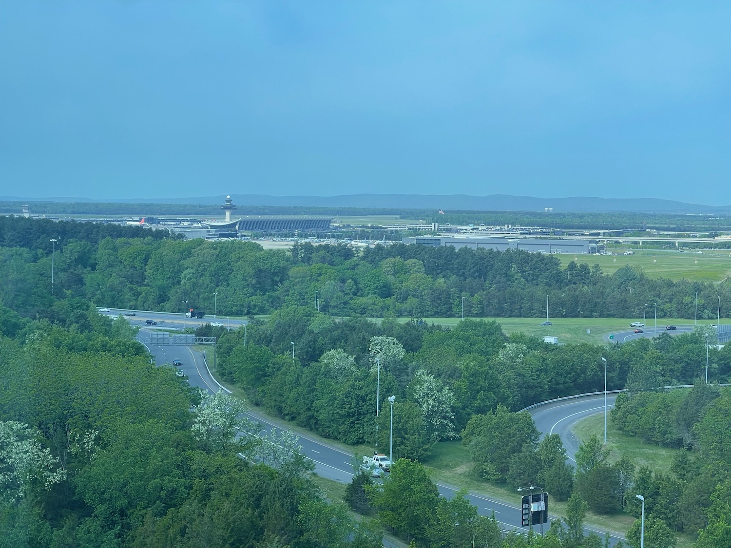 a road with trees and buildings in the background