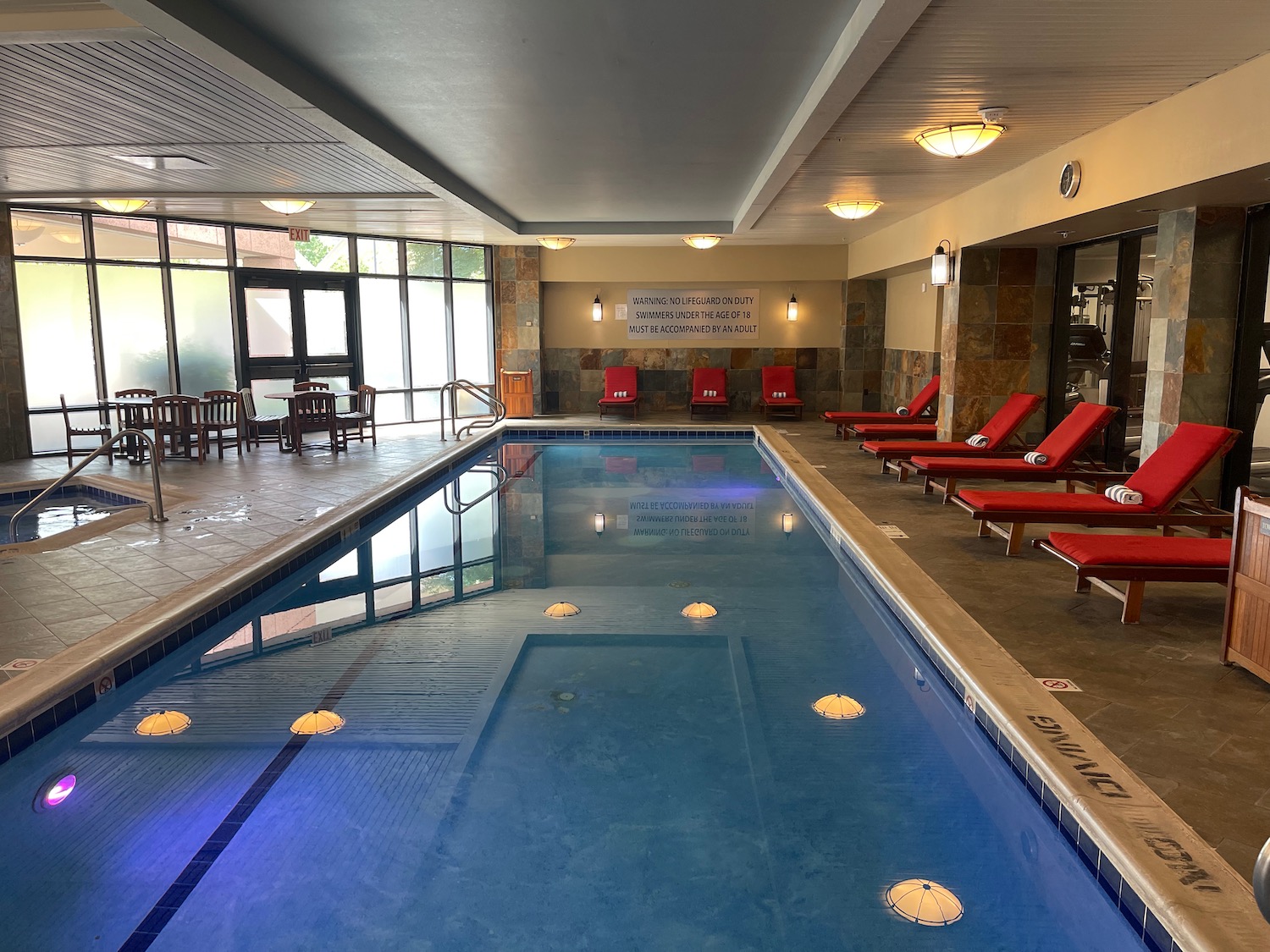 a pool with chairs and chairs in a room