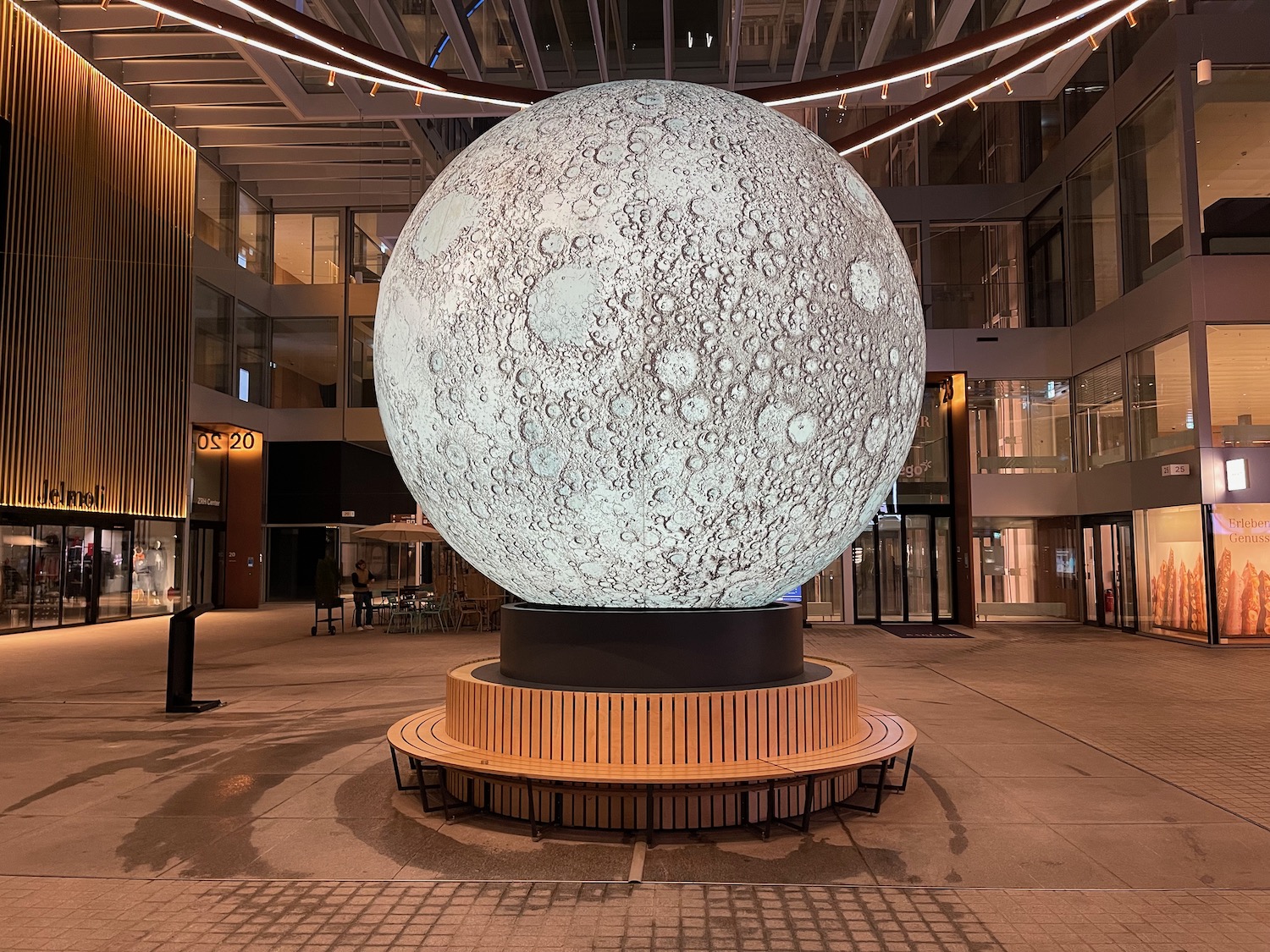 a large white sphere on a wooden stand in a building