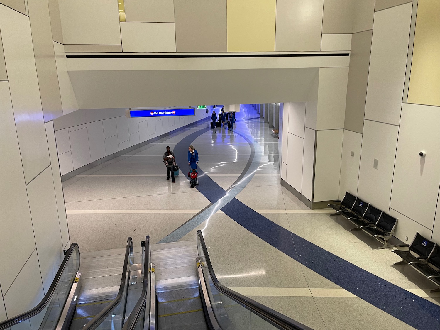 people walking in a building with an escalator