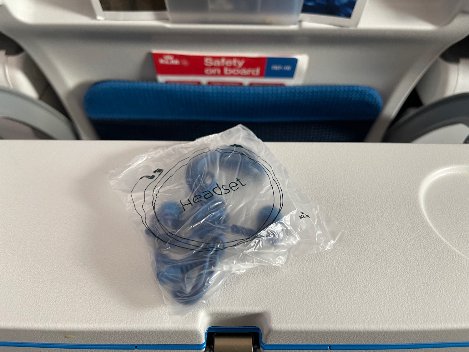 a plastic bag with earbuds on top of a white box