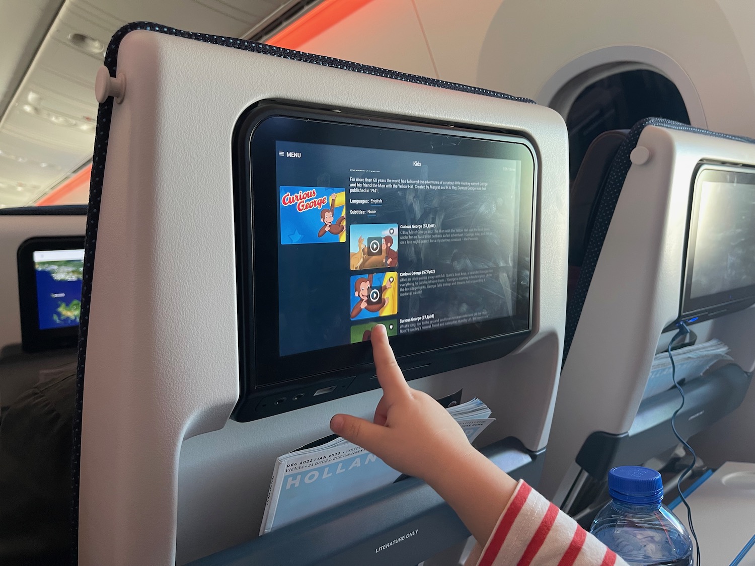 a child touching a screen on an airplane