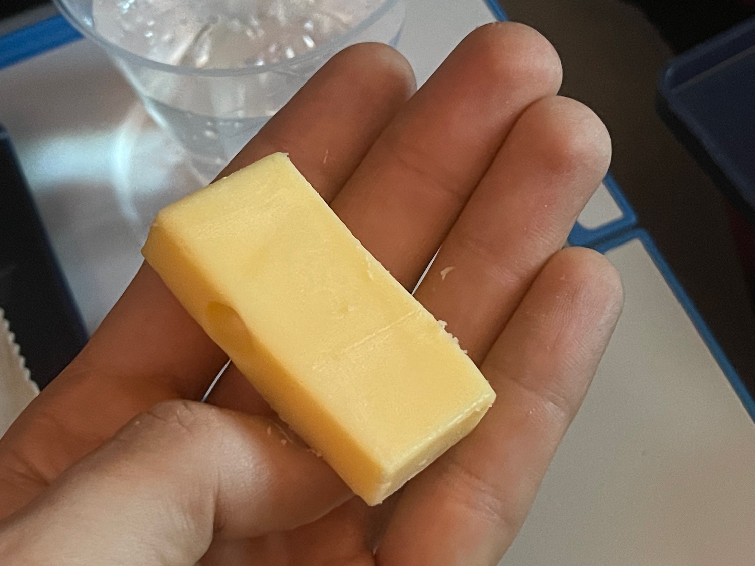 a hand holding a piece of butter
