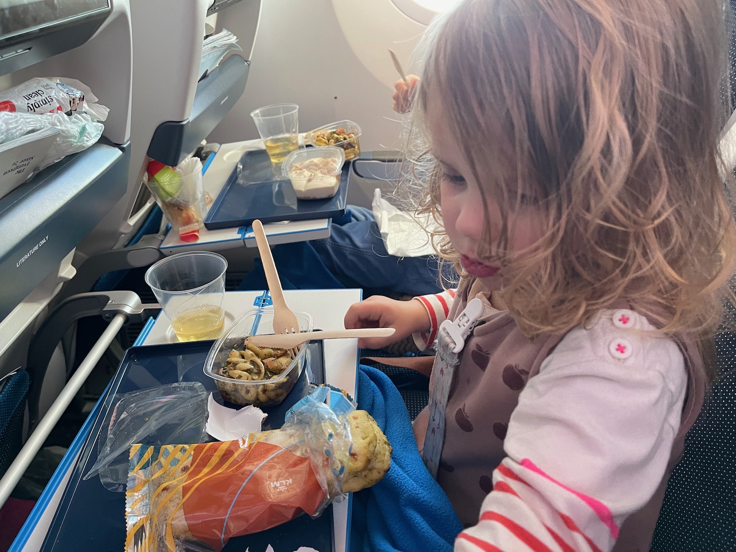 a child eating food on an airplane