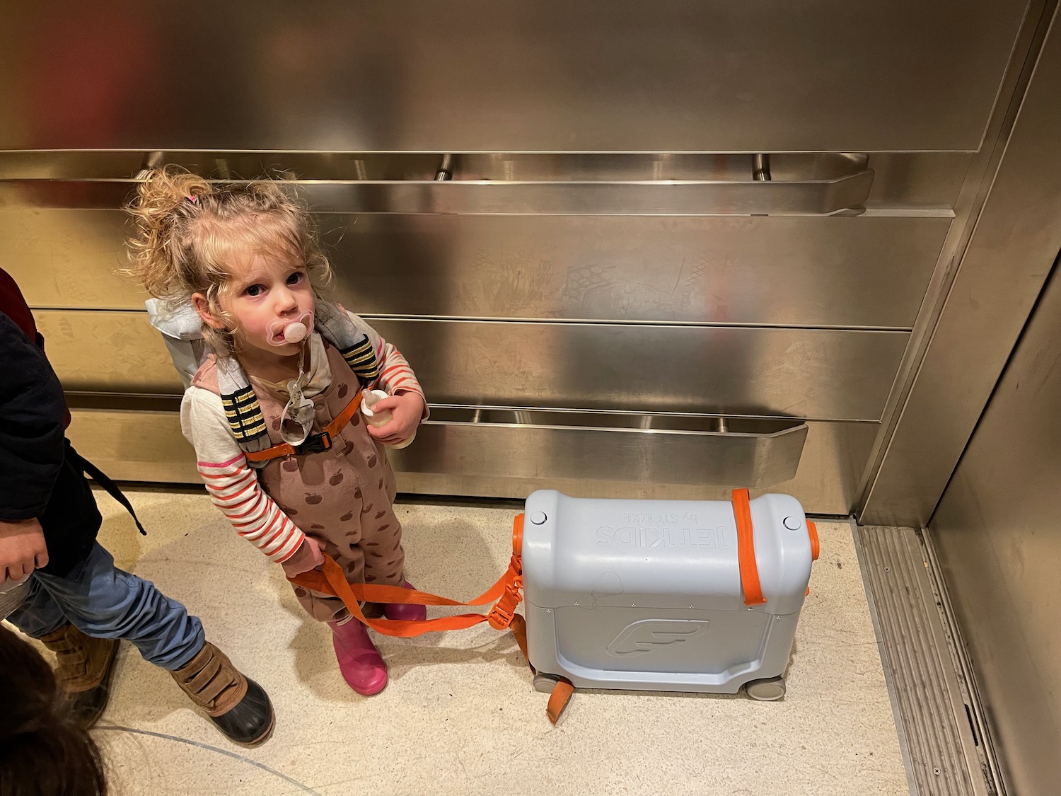 a girl standing next to a luggage case