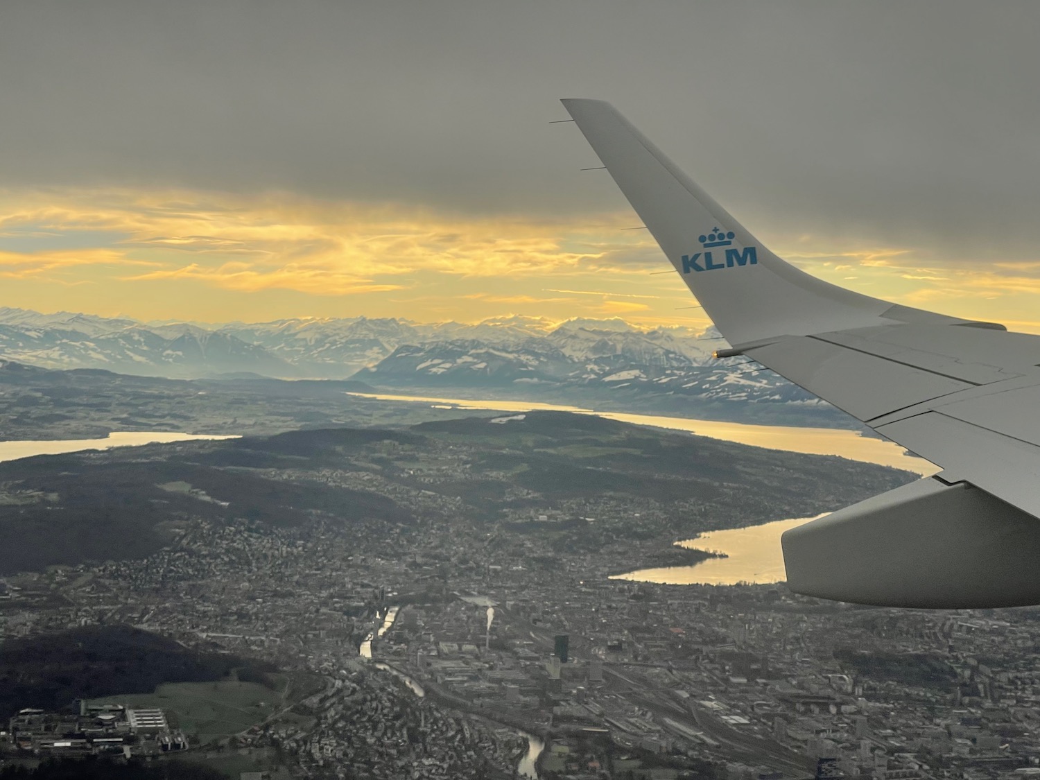 an airplane wing and a city and mountains