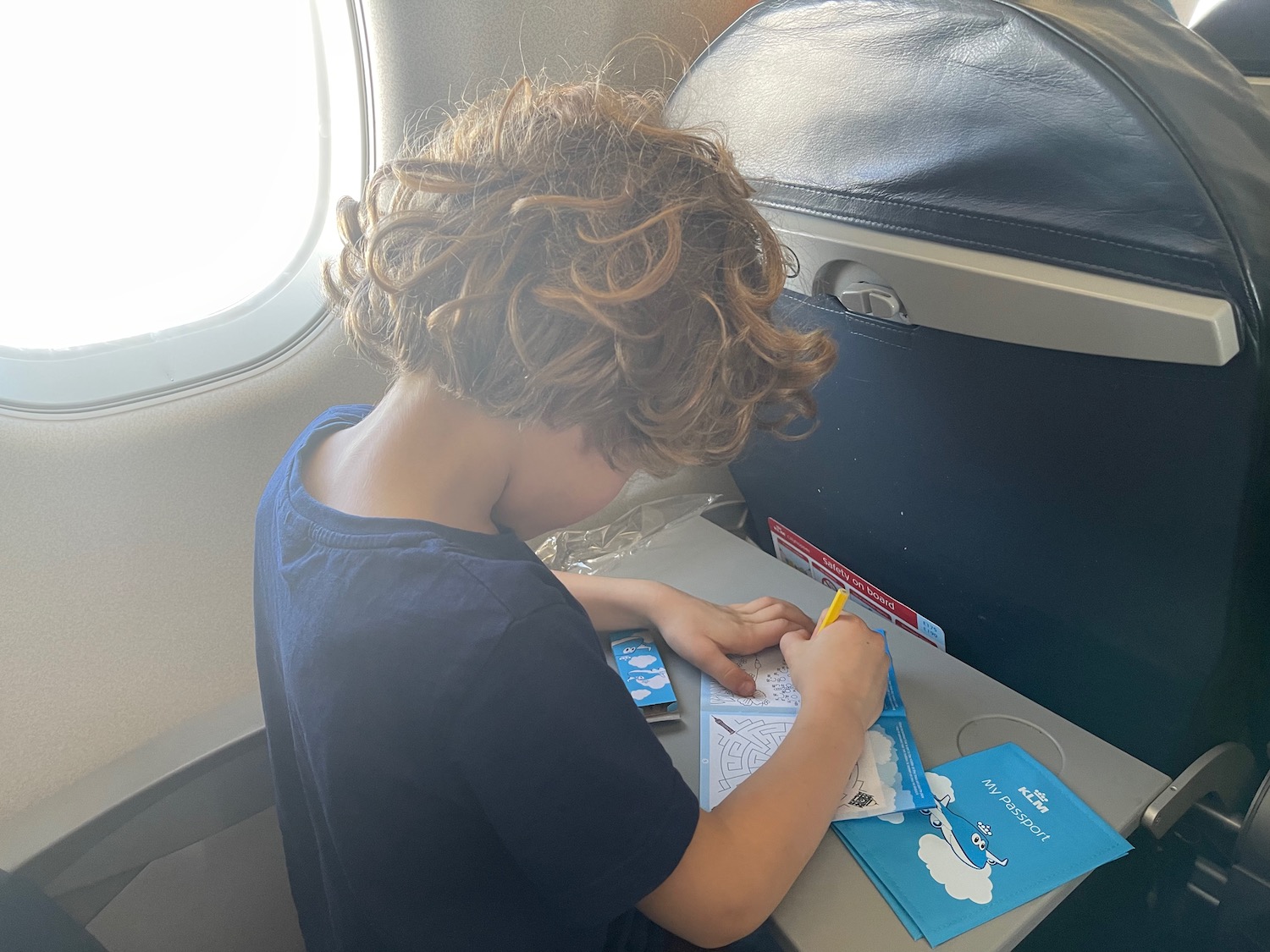 a child sitting at a desk in an airplane