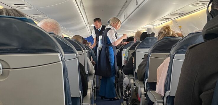 a man and woman standing in an airplane