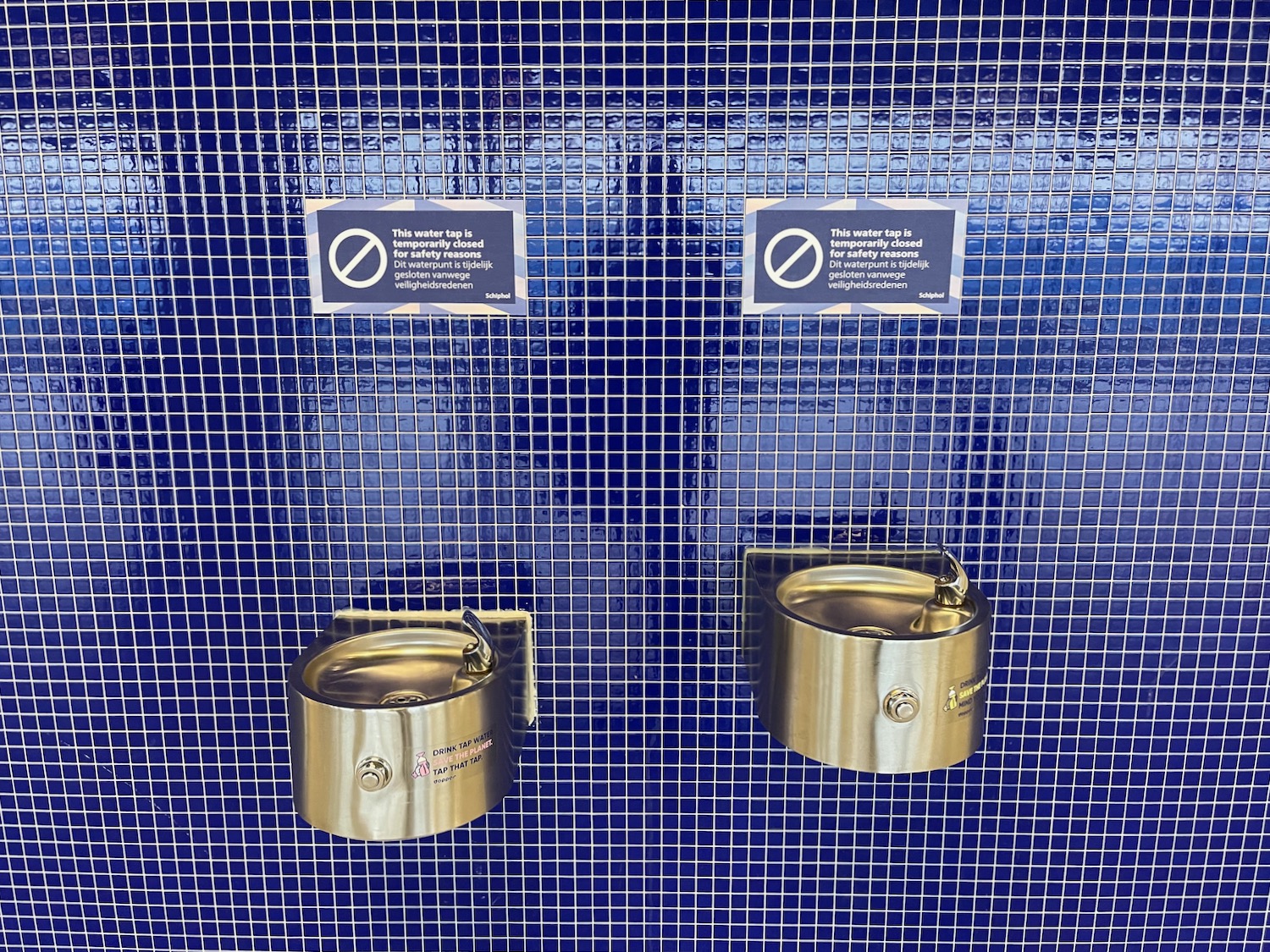 a water fountain on a blue tile wall