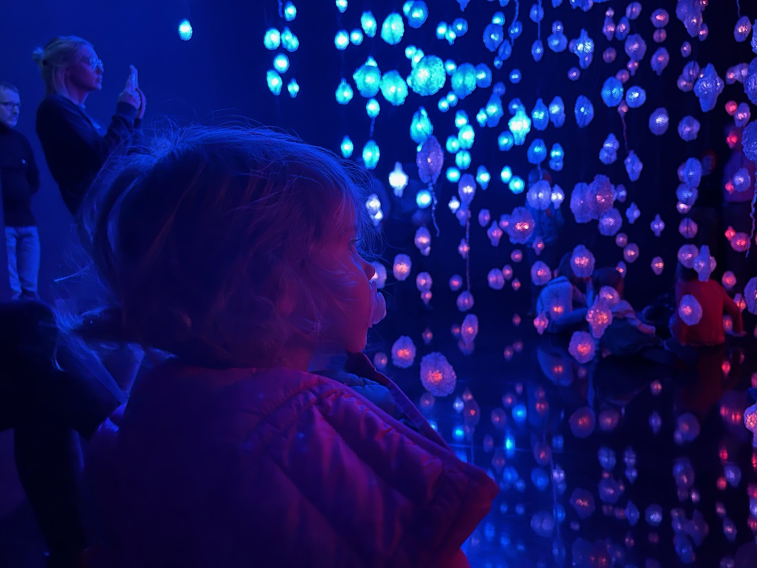 a child looking at a wall of lights