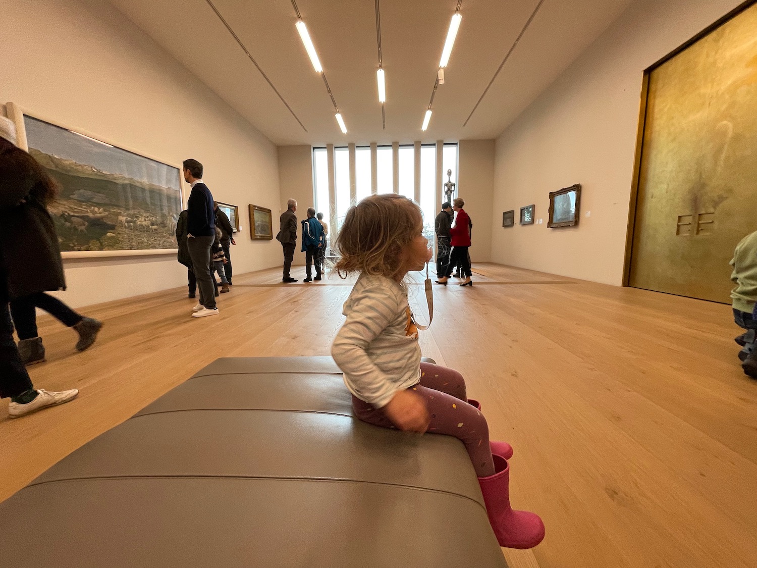 a child sitting on a bench in a museum