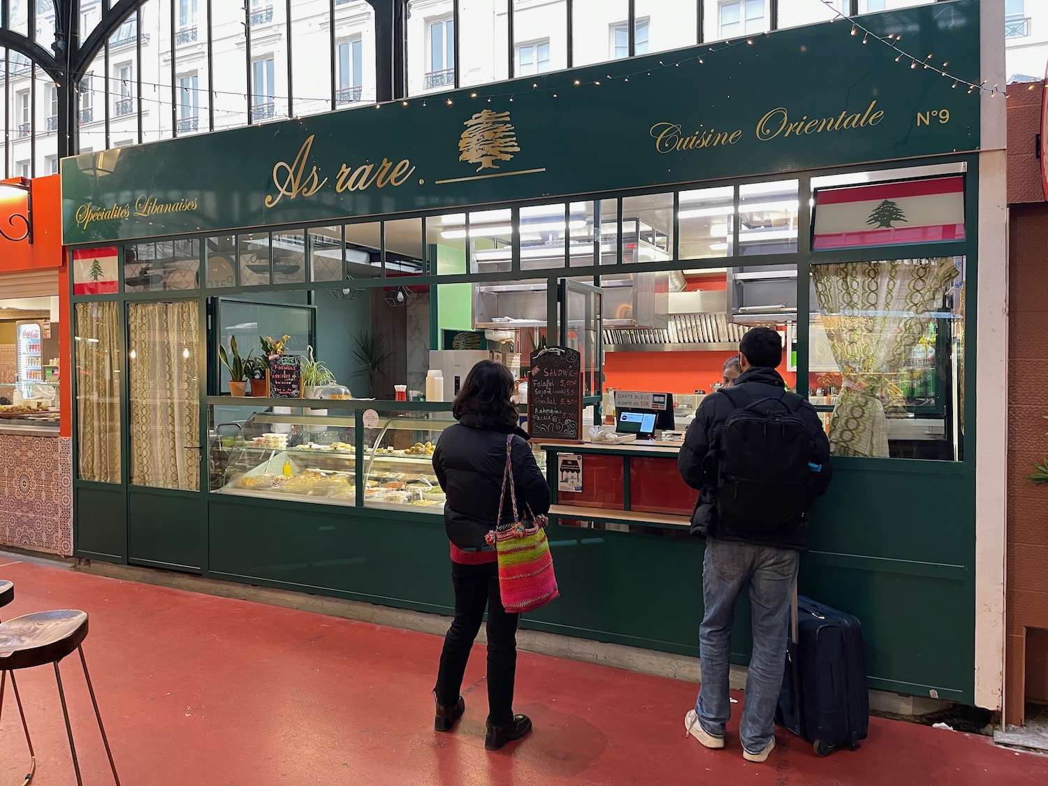 a man and woman standing in front of a restaurant