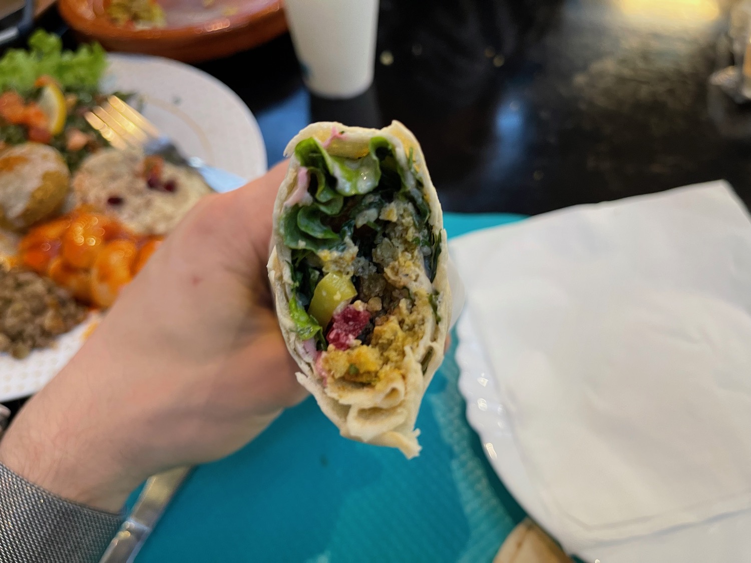 a hand holding a burrito