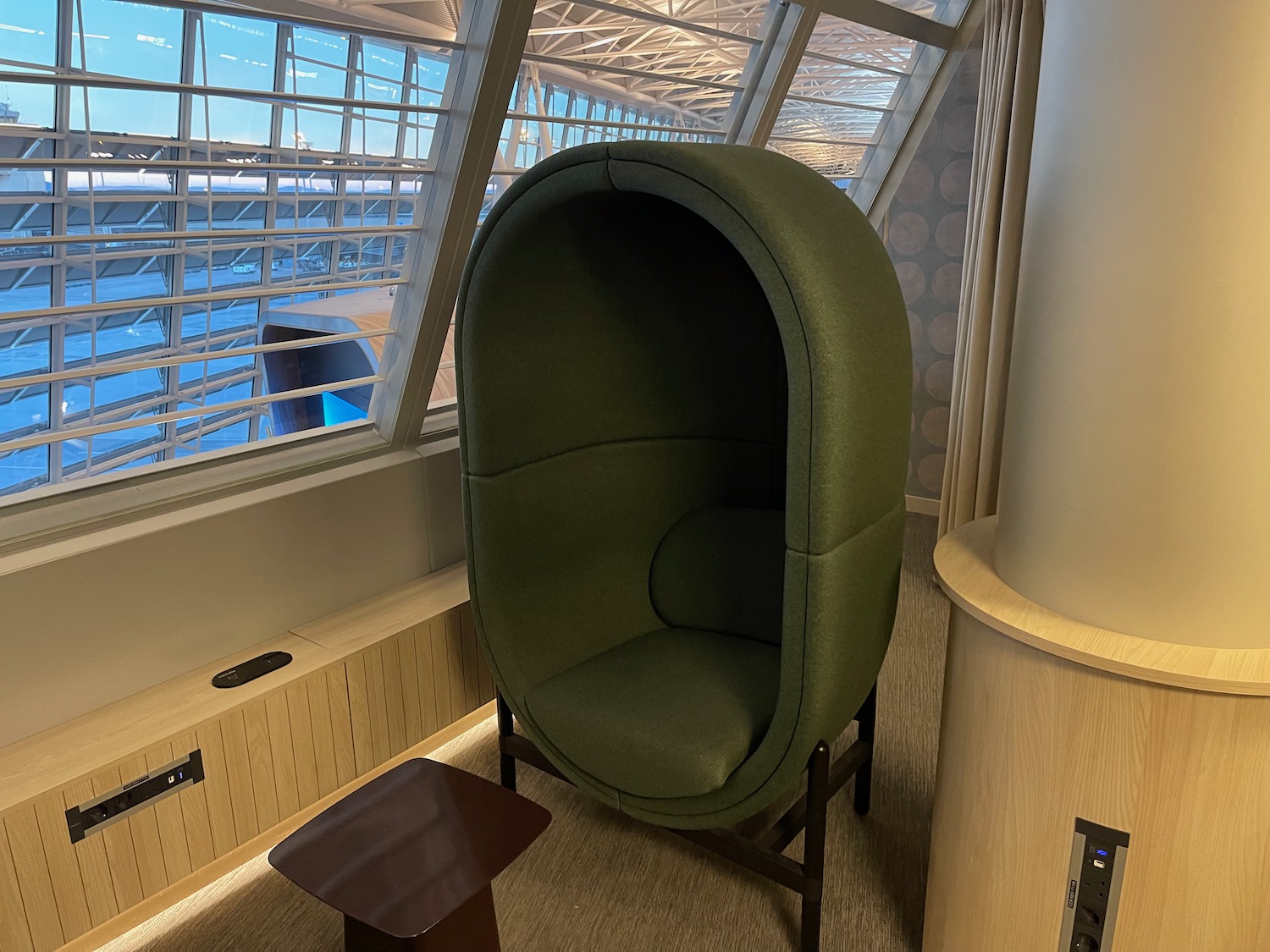 a green chair in a room with windows