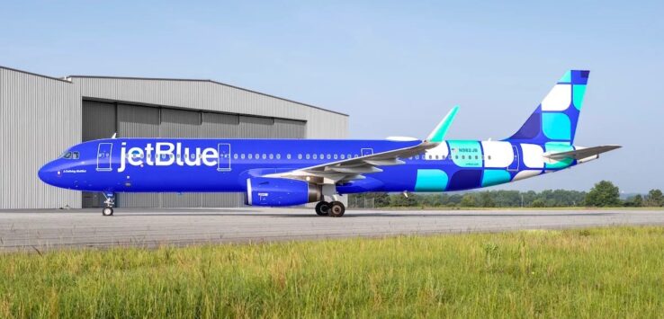 a blue and white airplane on a runway