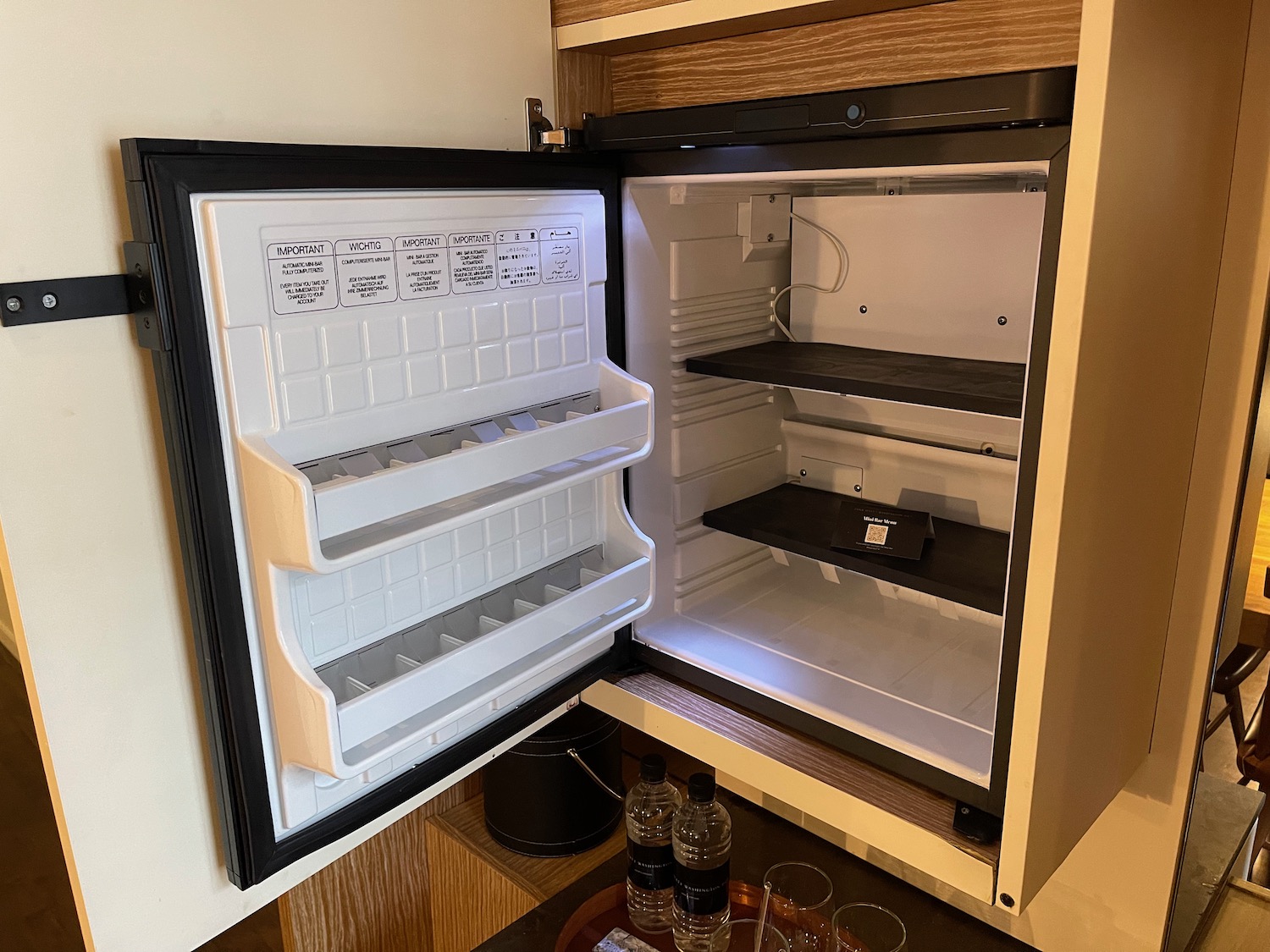 a small refrigerator with shelves and bottles of water