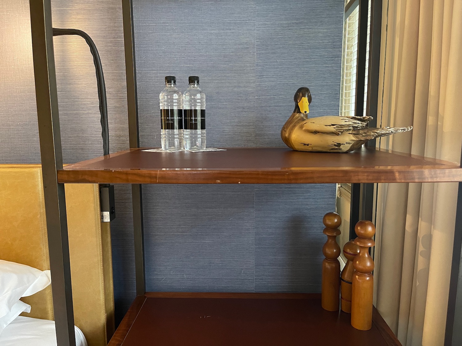 a wooden shelf with a duck statue and bottles on it