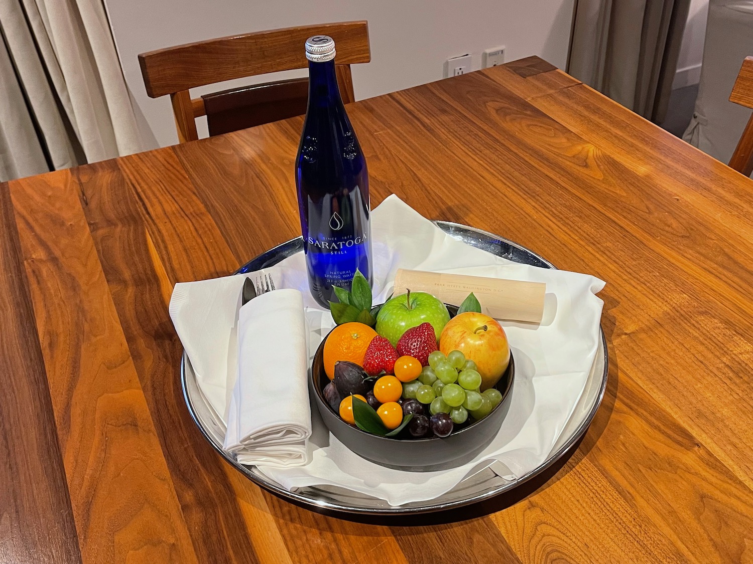 a bowl of fruit and a bottle of water on a table