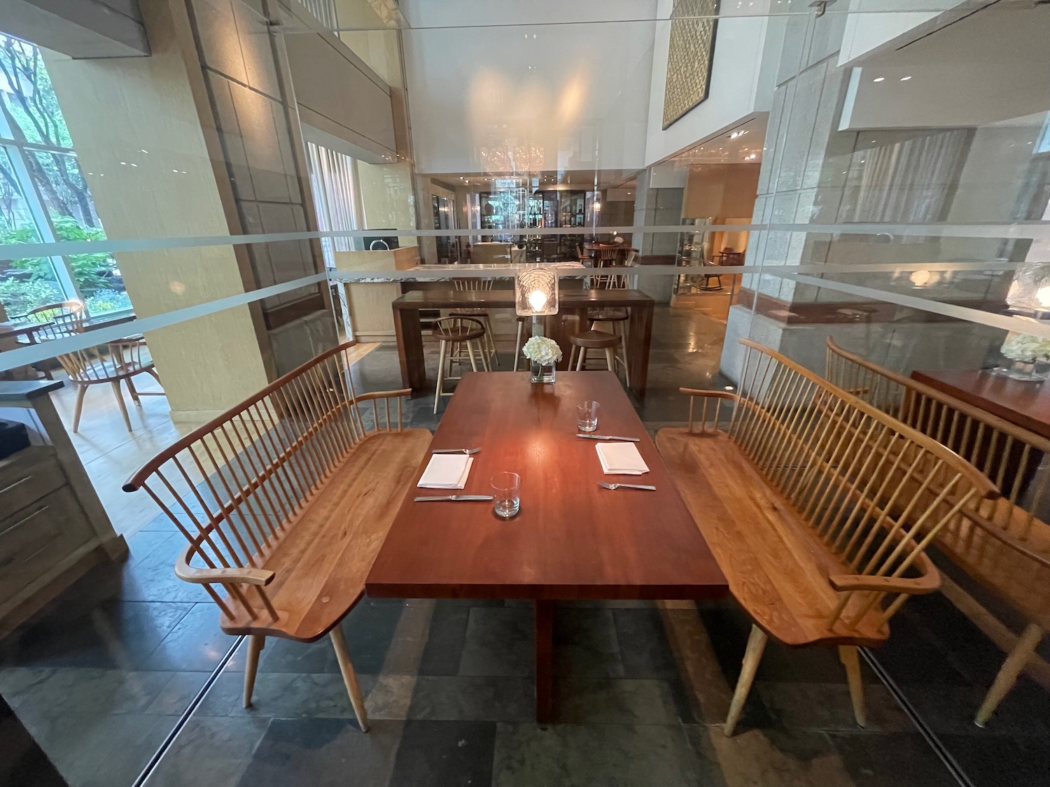 a table with chairs and a glass wall behind it
