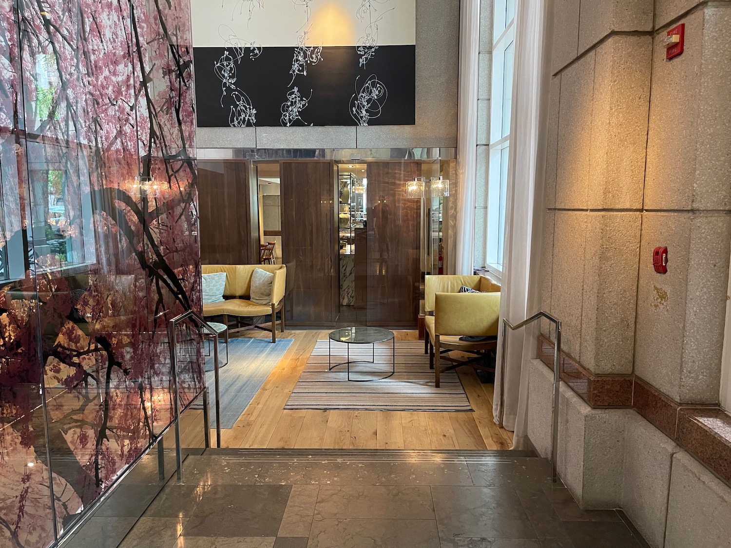 a lobby with a glass wall and chairs