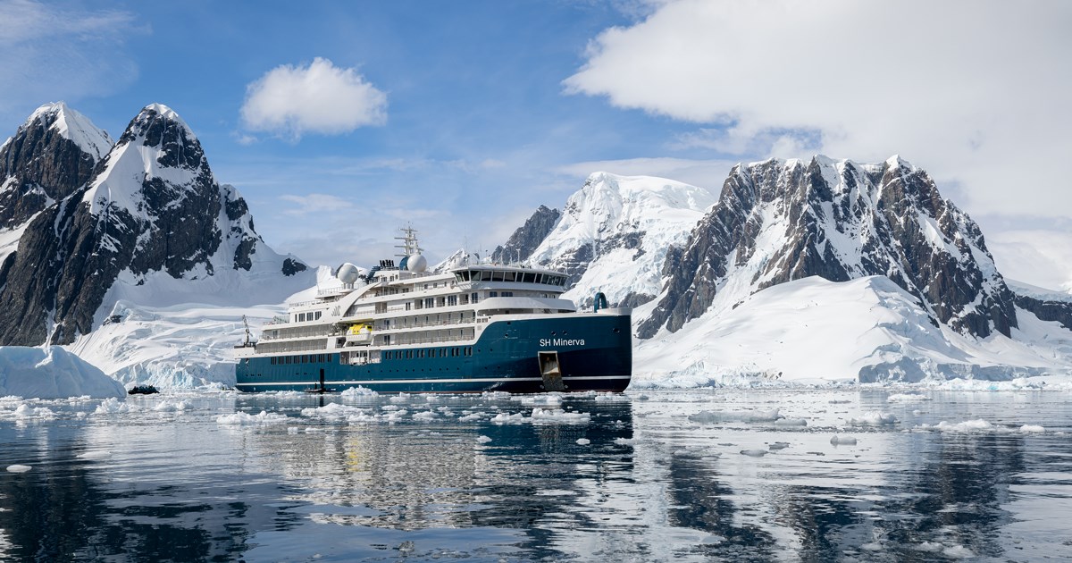 a ship in the water with mountains in the background