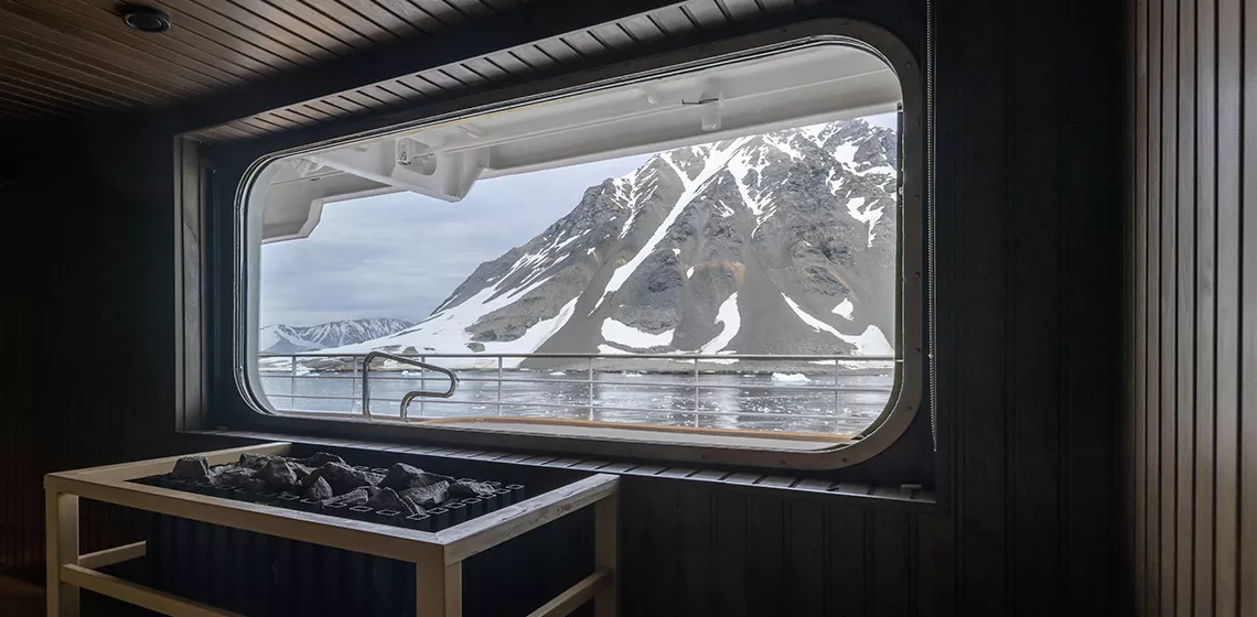 a view of a snowy mountain from a boat window