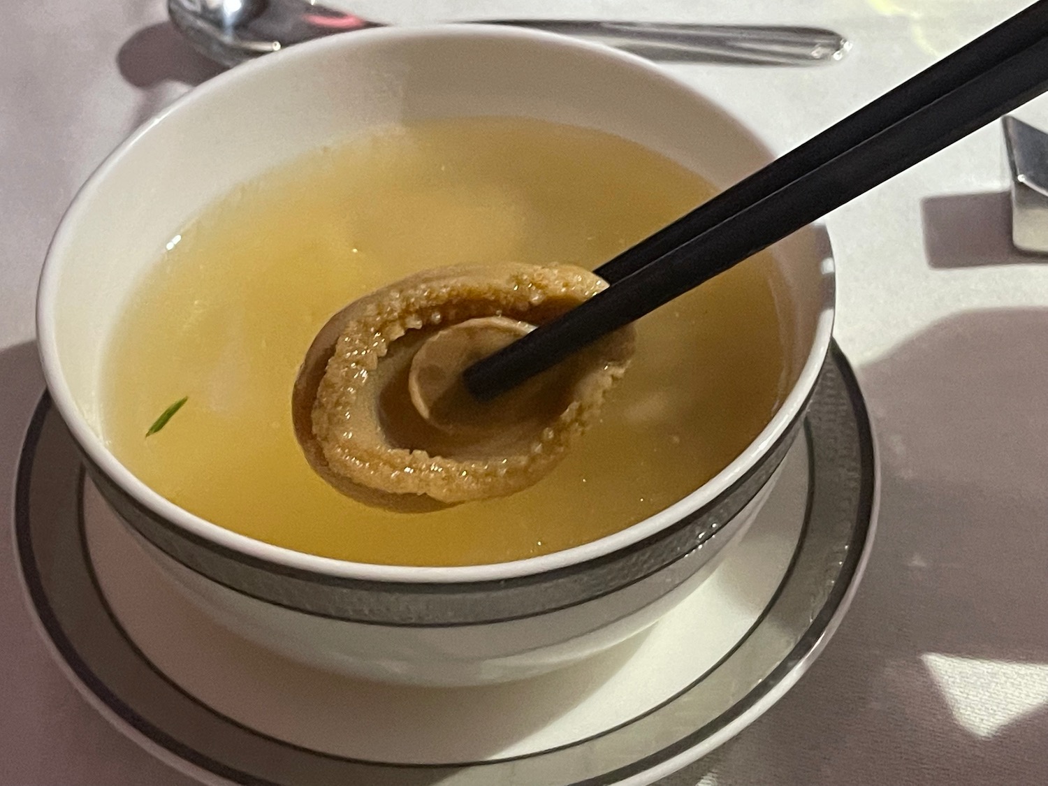 a bowl of soup with a piece of food in it