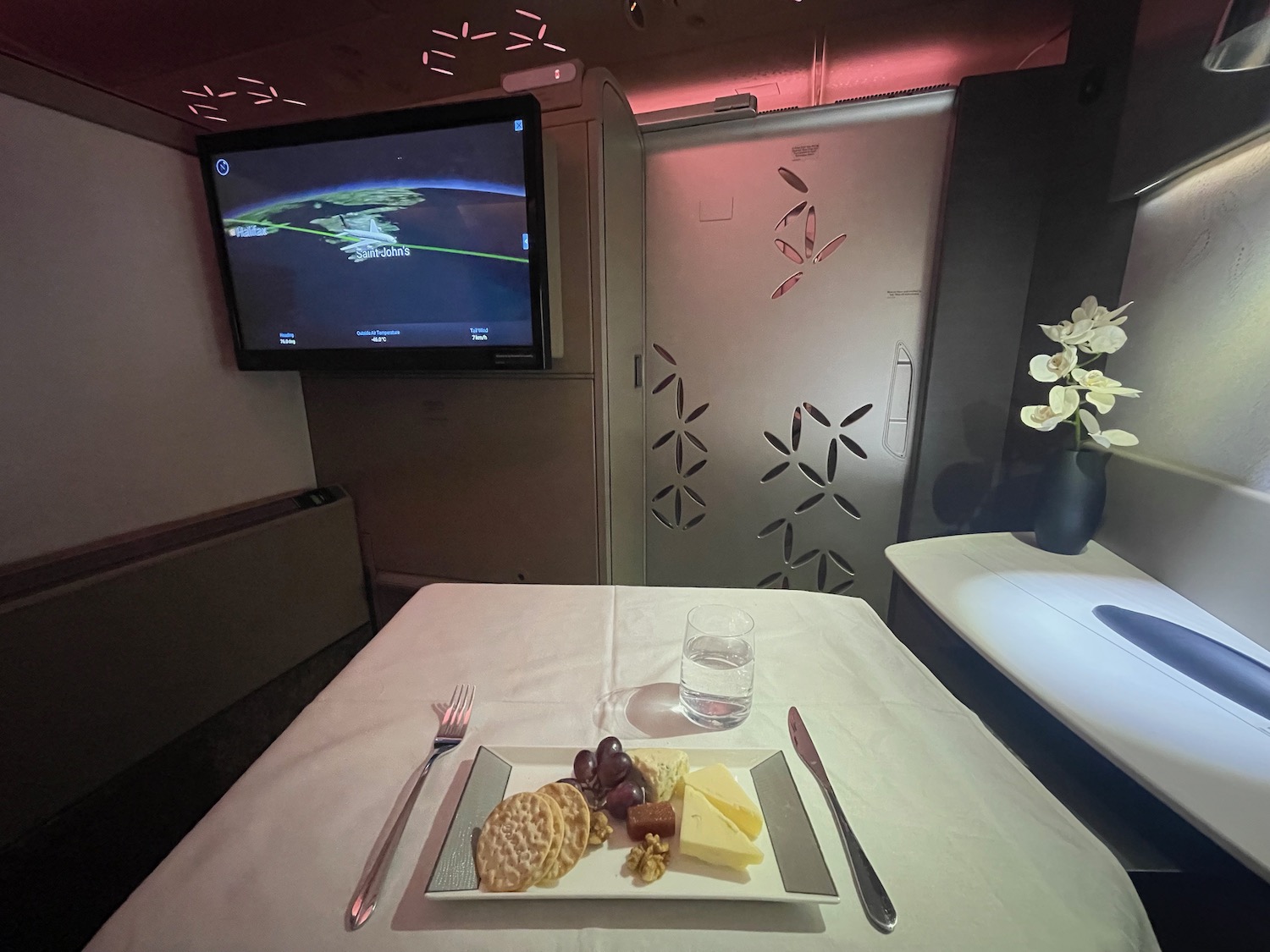 a plate of food on a table with a television in the background