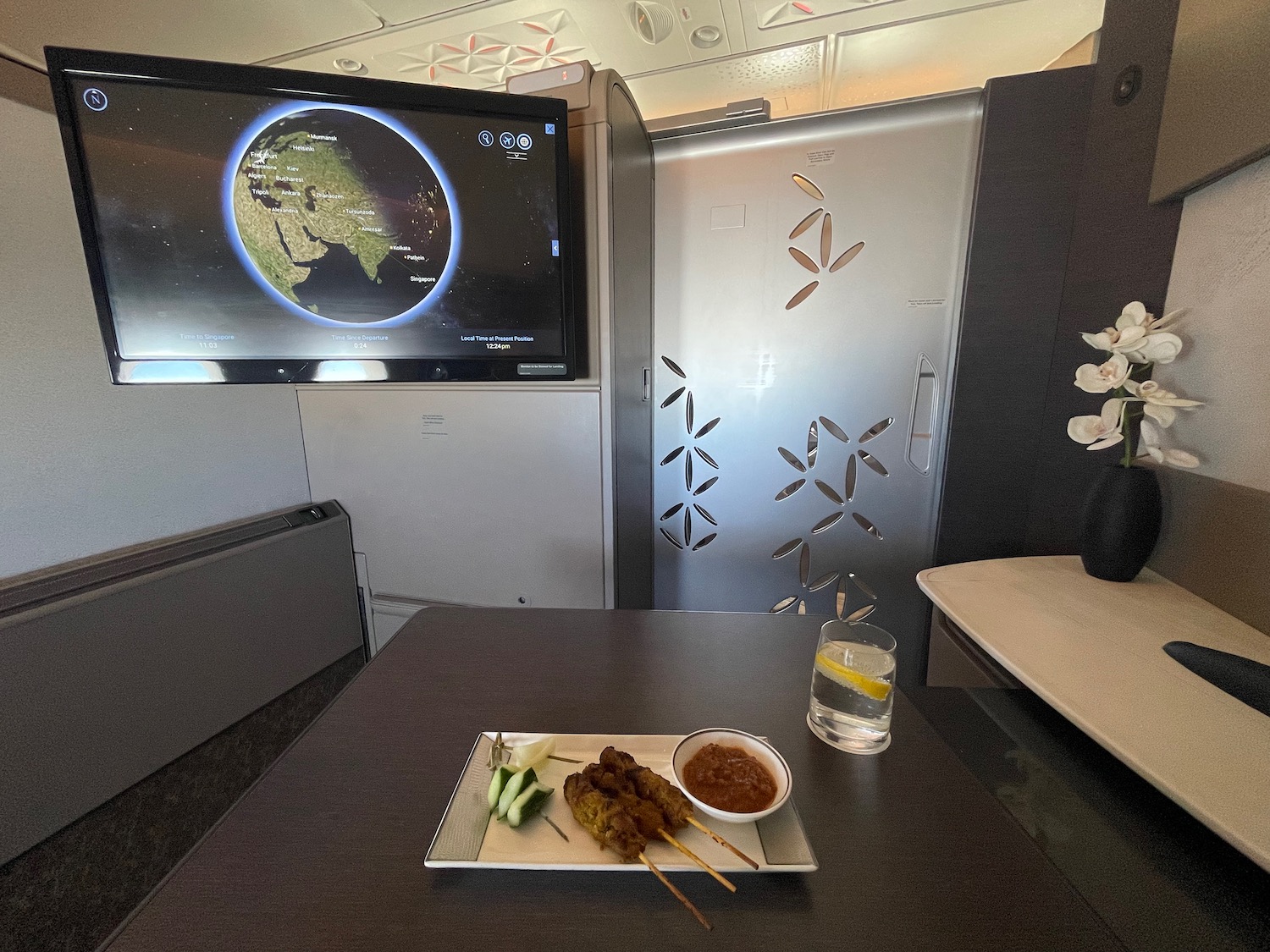 a plate of food on a table with a television on the wall