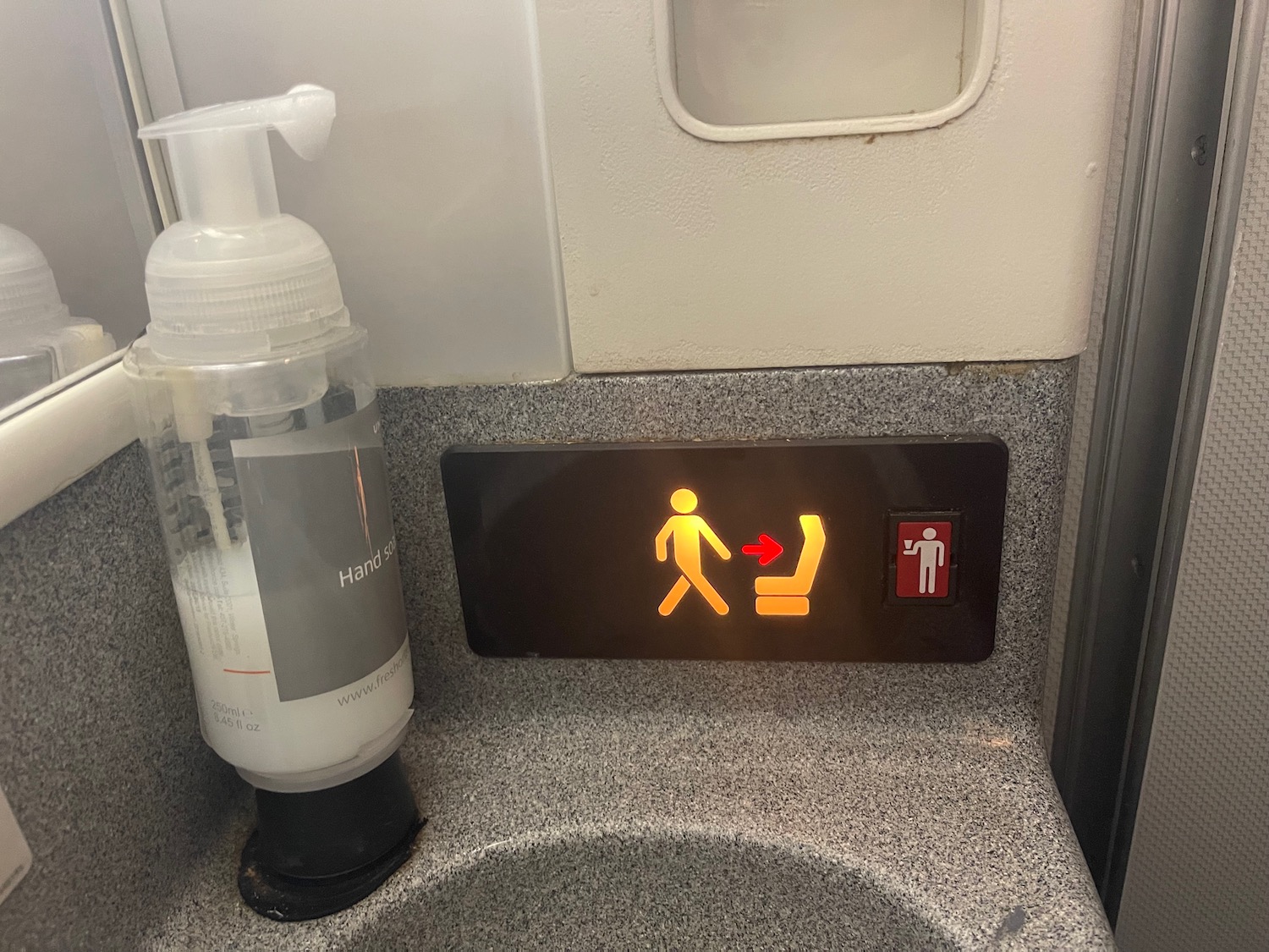 a hand sanitizer and a sign on a sink