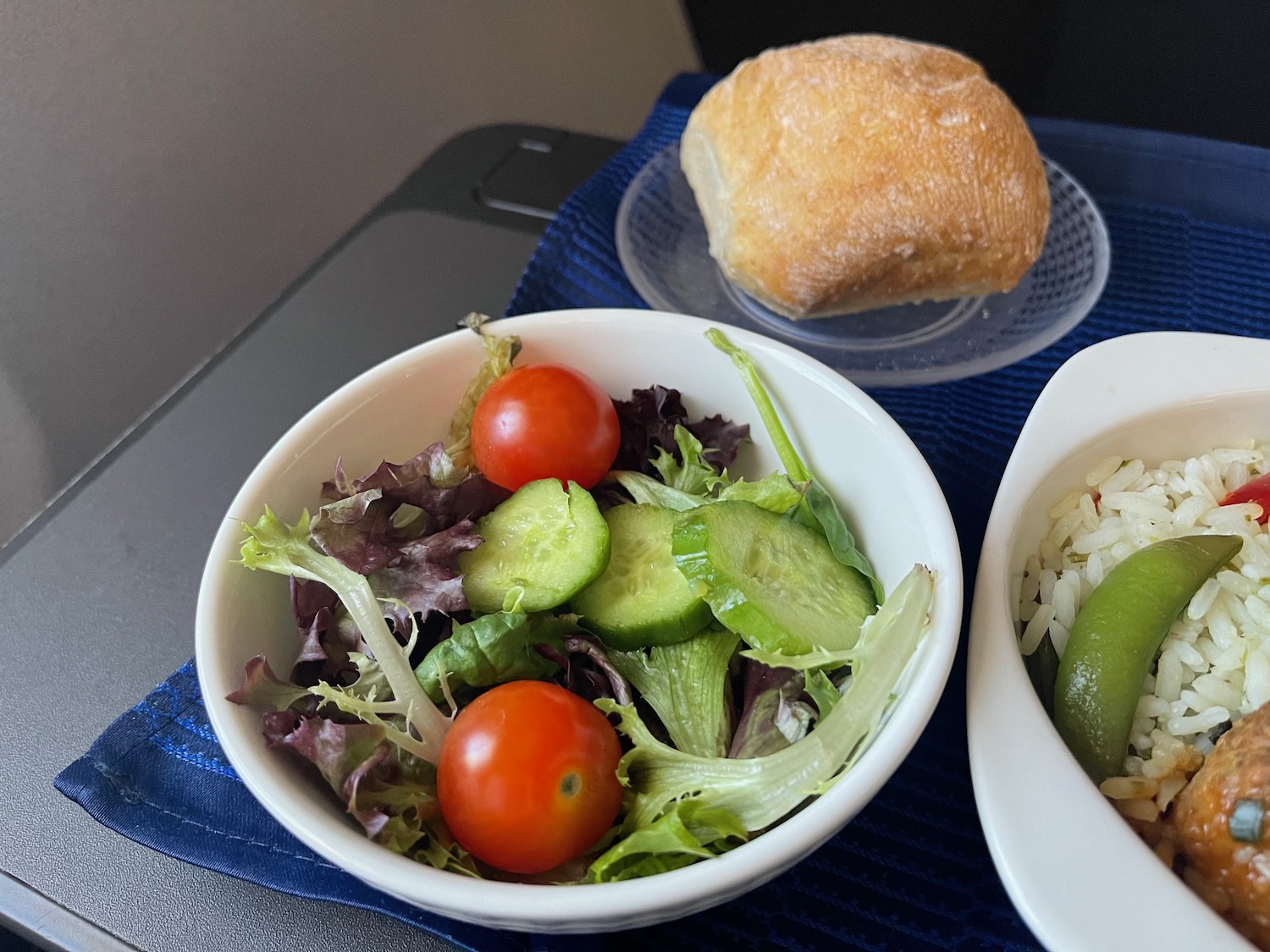 a bowl of salad and a roll