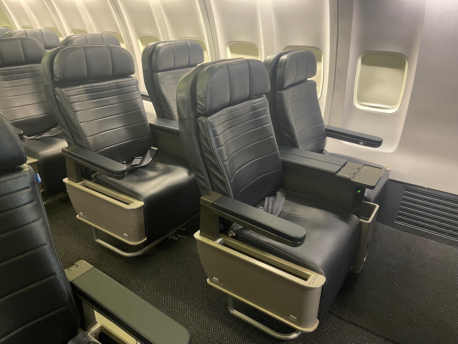 a row of black chairs in an airplane