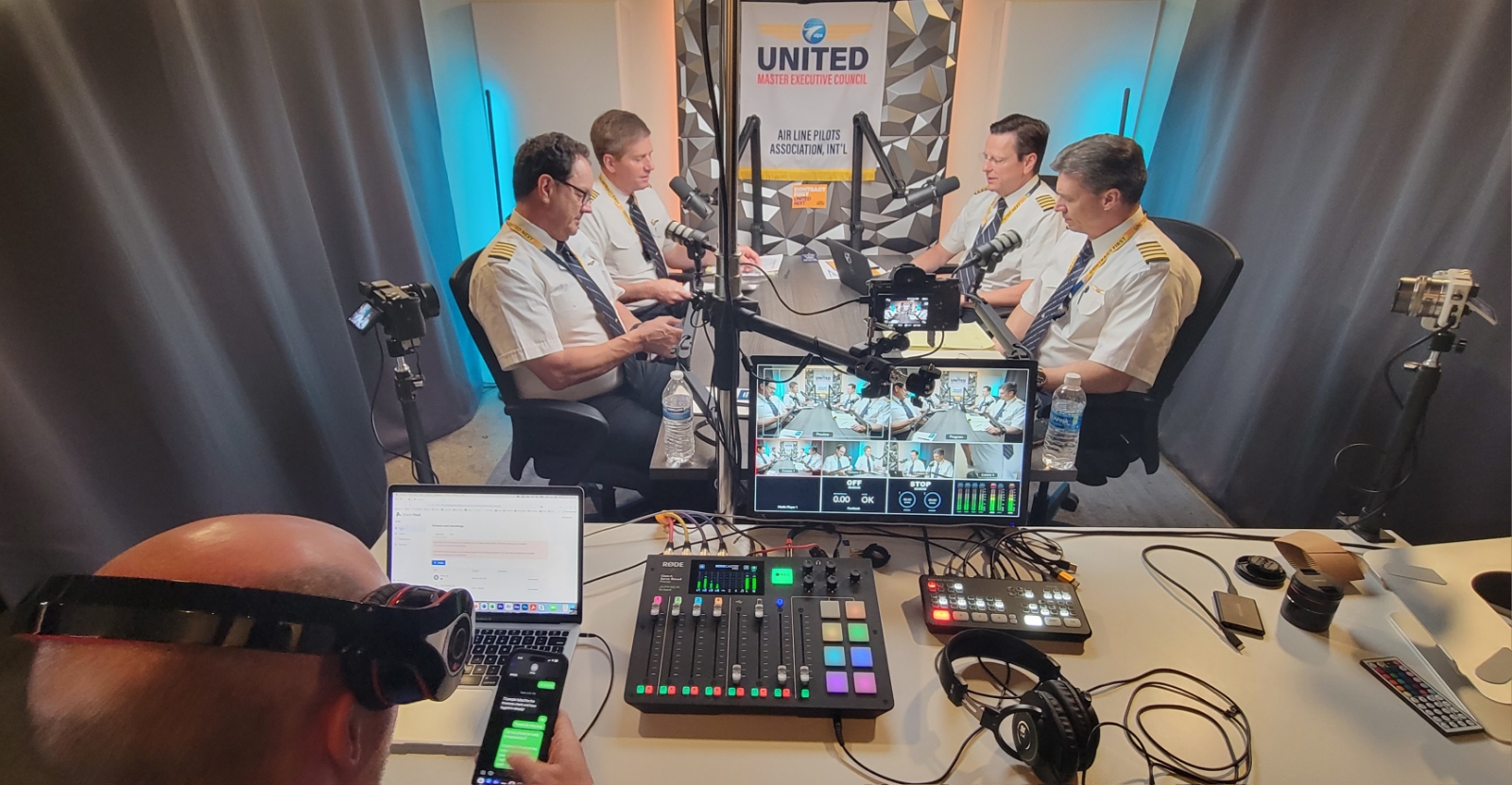 a group of men in a room with a microphones and a camera