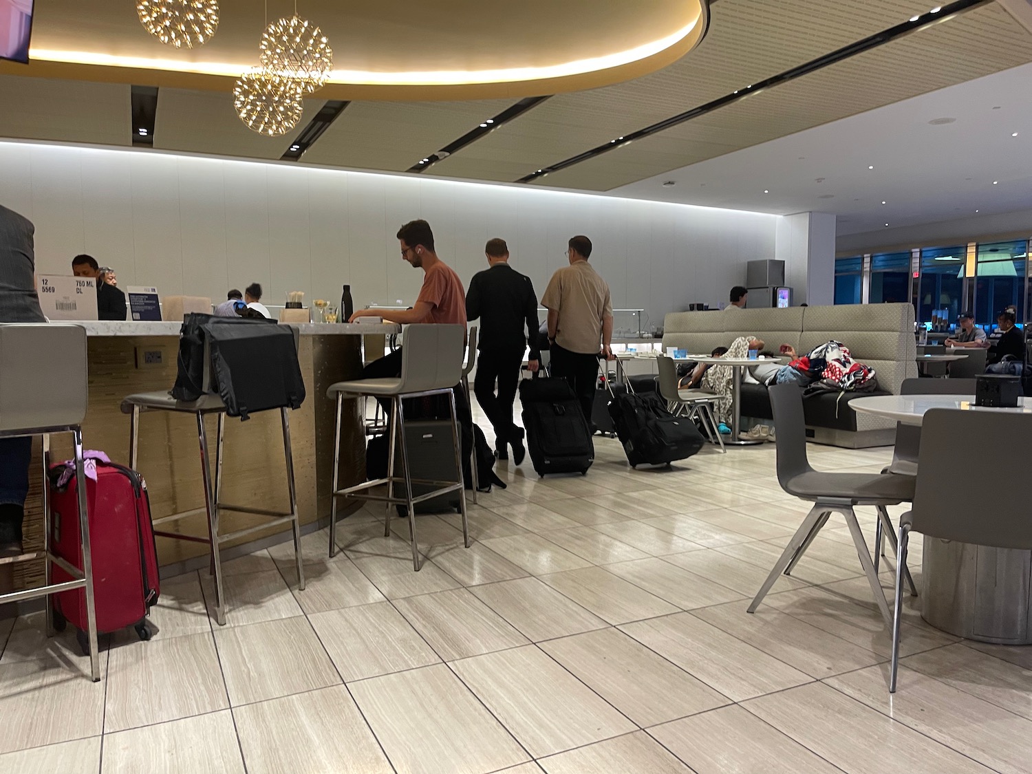 people standing at a counter in a room with luggage
